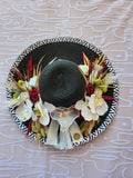 Chapeau de paille noir zébré orné d'orchidées blanches, roses rouges et fleurs séchées